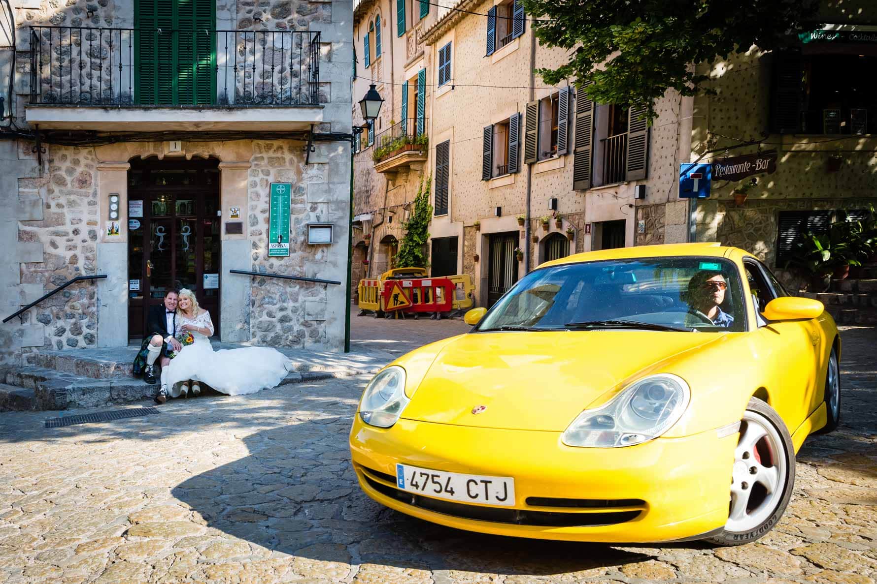Bride and groom and yellow Porsche in Valldemossa