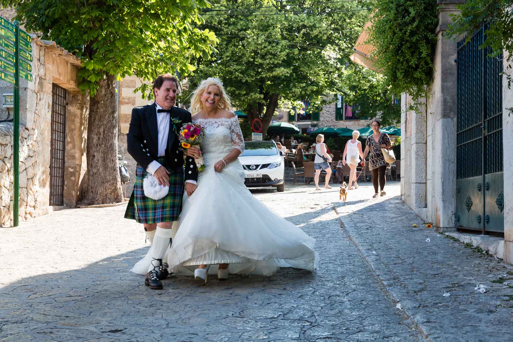 Happy bride and groom walking in Valldemossa after their Mallorca wedding