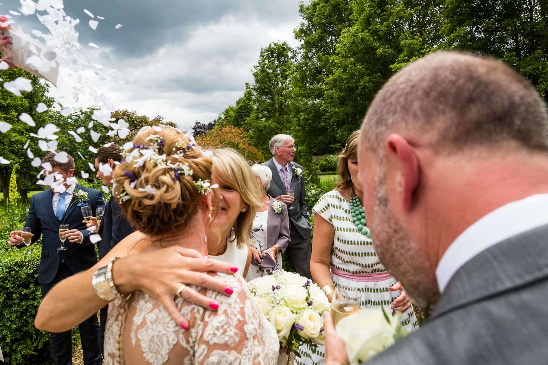 A hug and a kiss for the bride at Hanbury Manor wedding by Hertfordshire wedding photographer Graham Warrellow