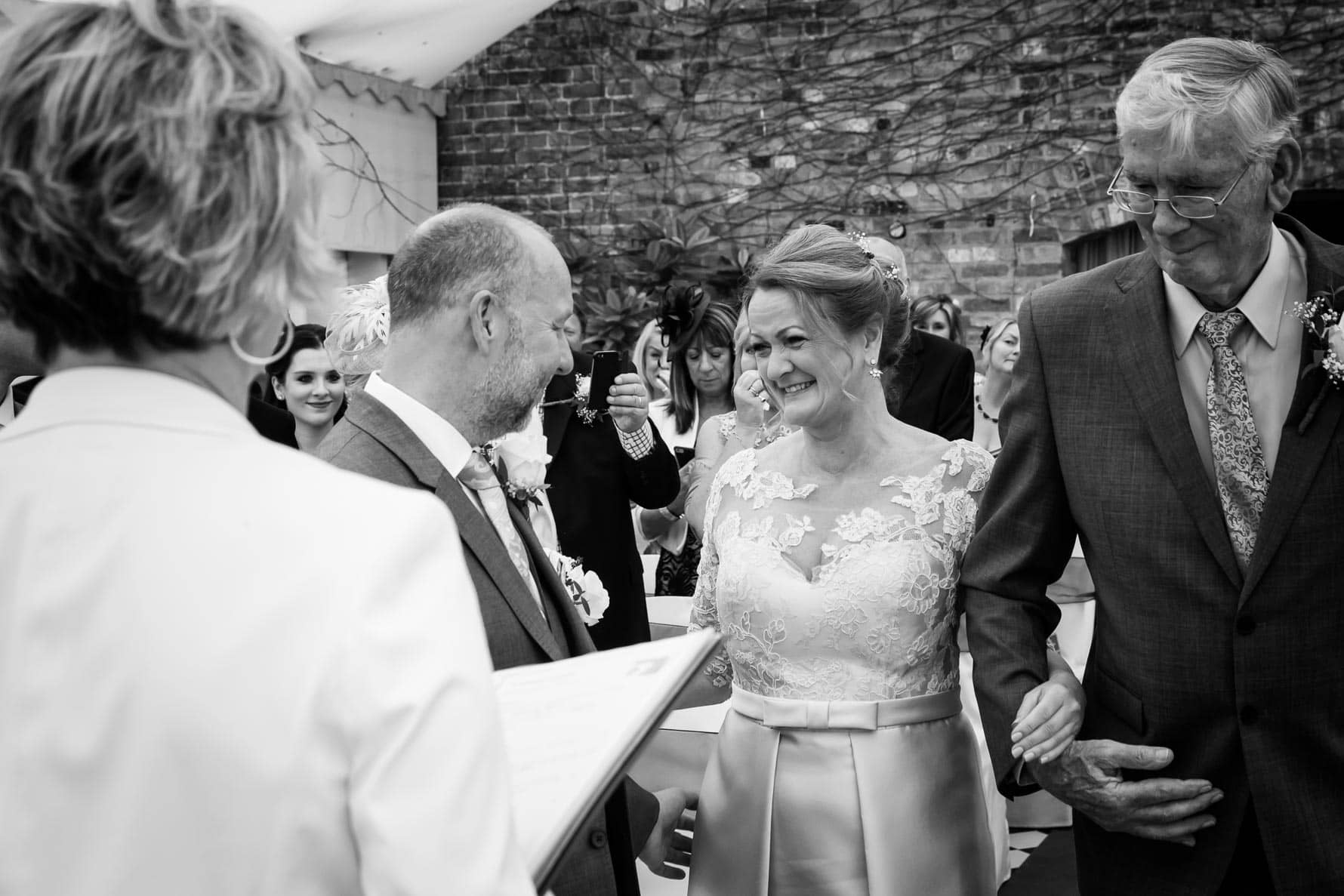 The groom greets his bride at their Hertfordshire wedding at Hanbury Manor