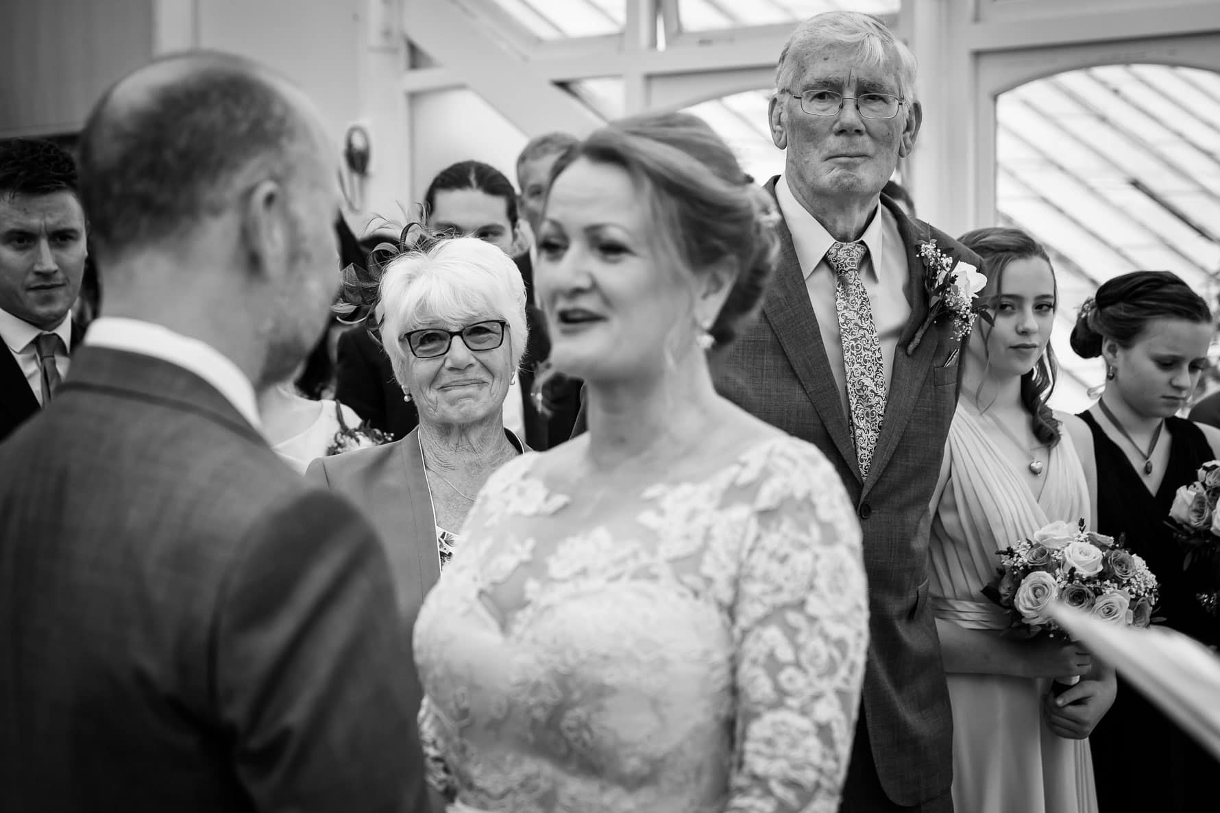 A proud mum looks on during the wedding ceremony at Hanbury Manor