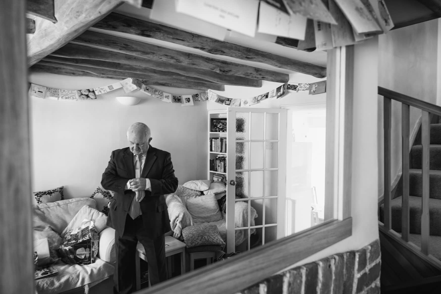 Dad checks his watch during Becky's bridal preparations by Hertfordshire wedding photographer