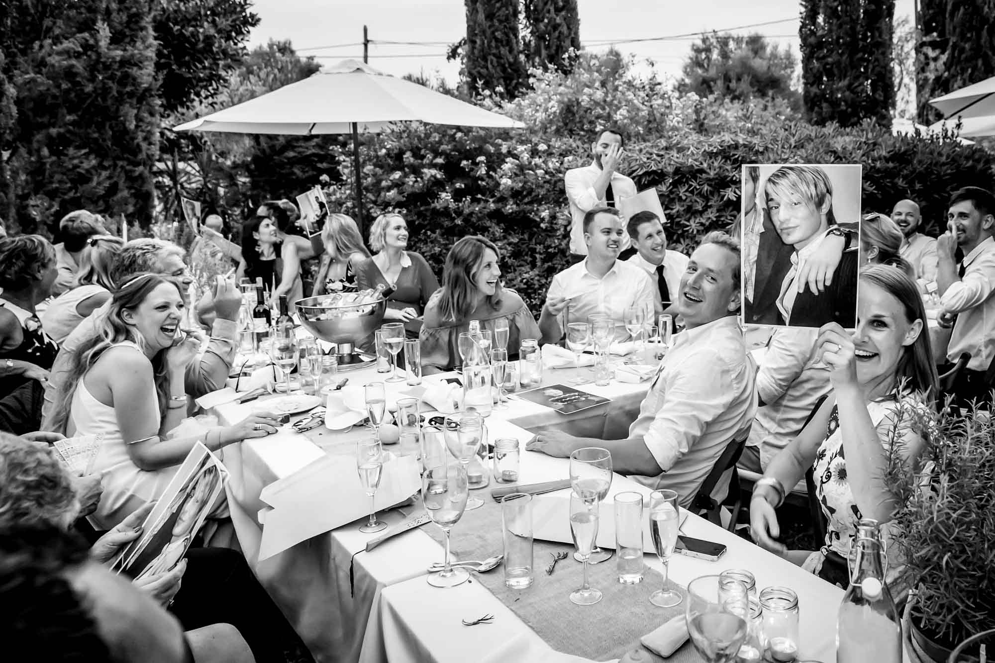 Photos of the groom are passed around during the best man's speech at the finca wedding captured by Mallorca wedding photographer Graham Warrellow