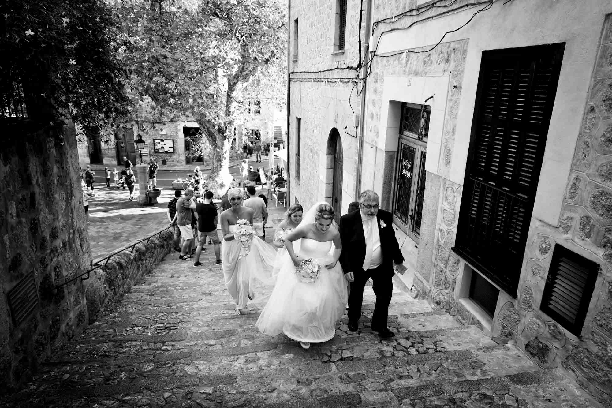 The bridal party walk up the steps to the church in Fornalutx