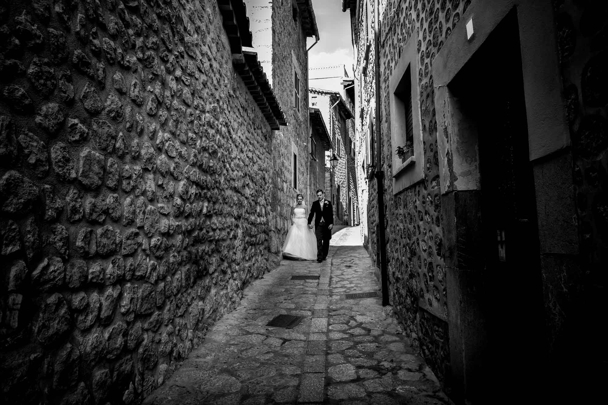 The bride and groom walk down the narrow streets of Fornalutx in Mallorca
