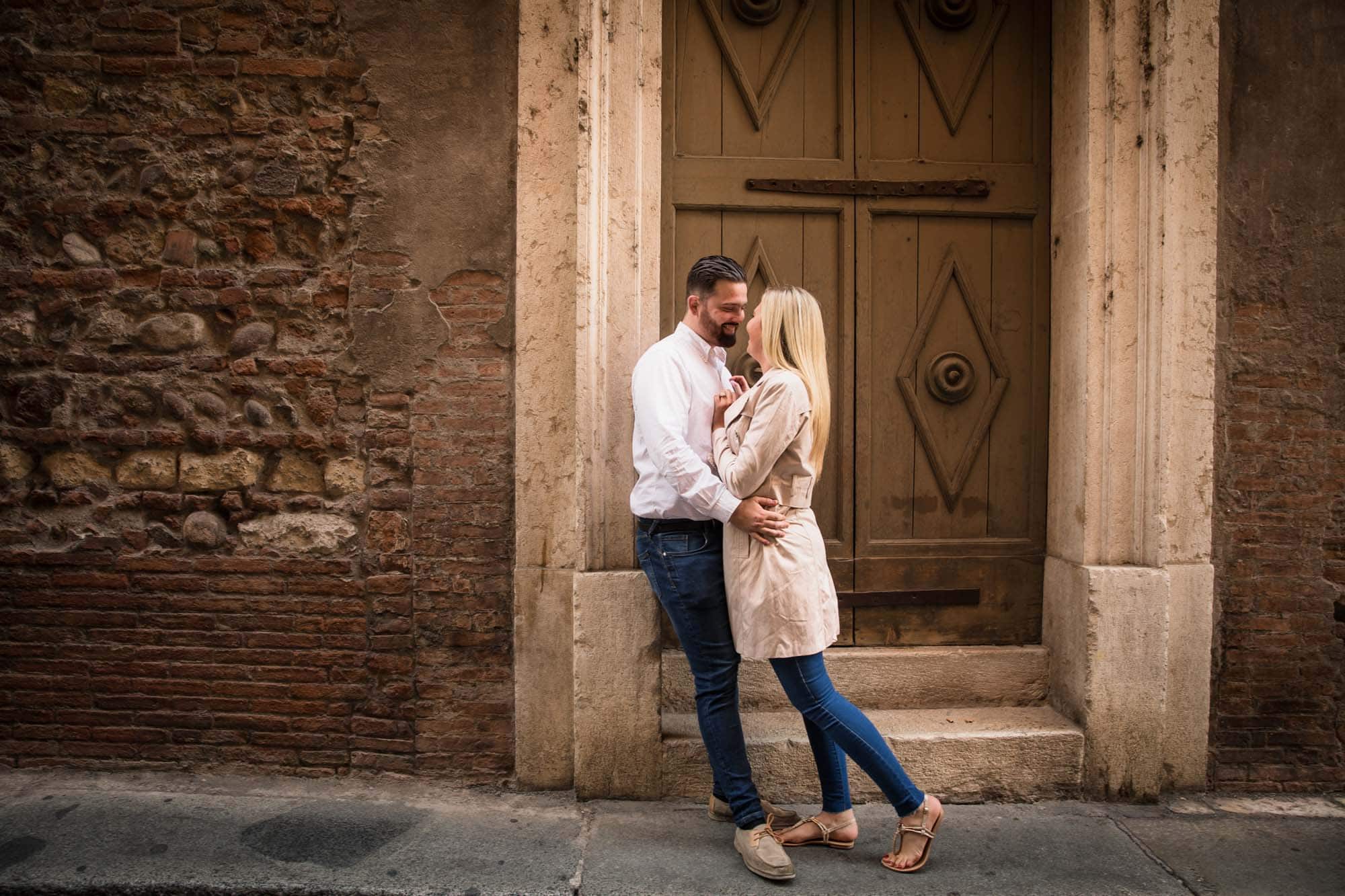 A romantic couple hug one another in Verona, Italy