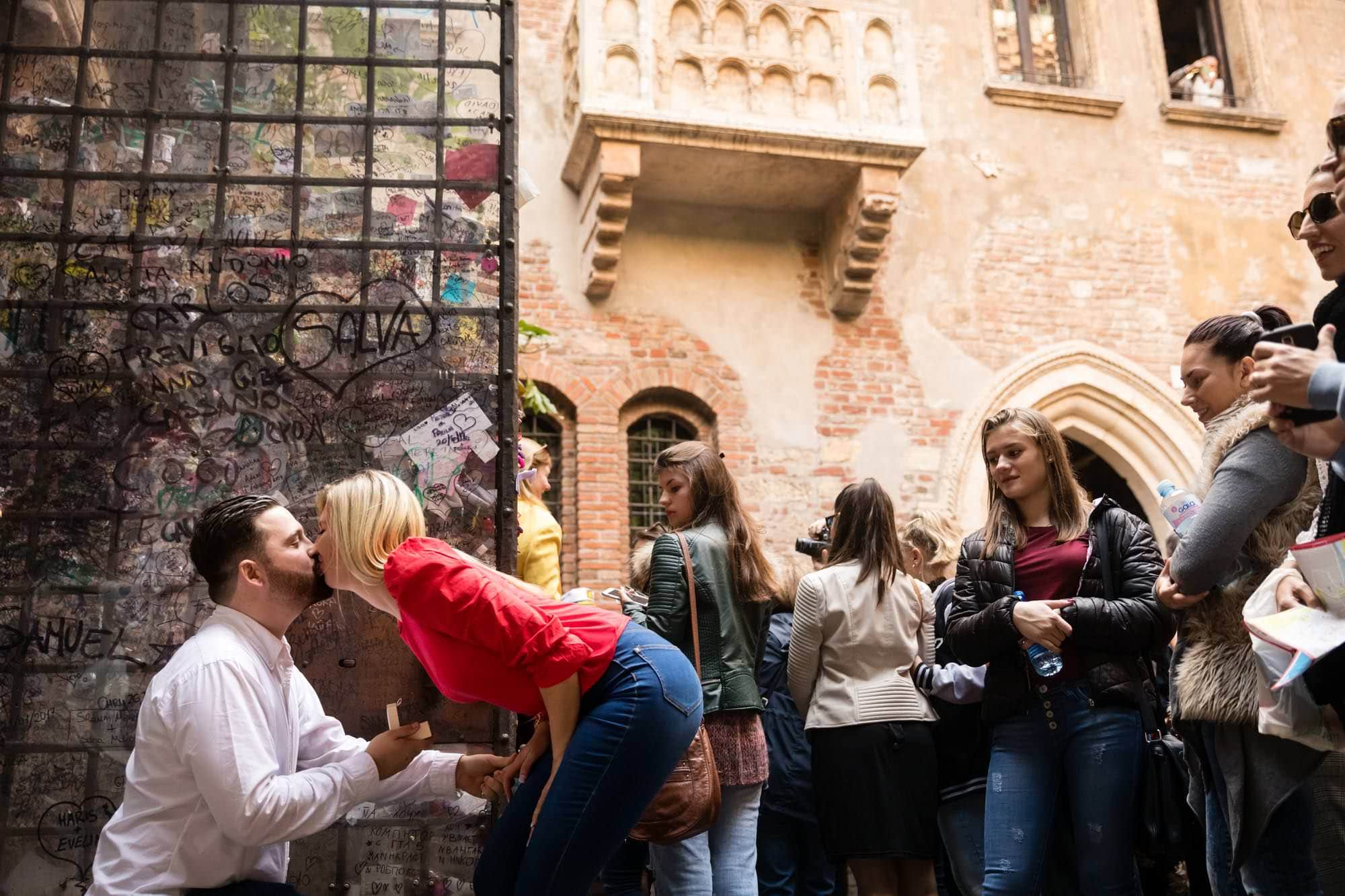 A romantic marriage proposal under the Romeo and Juliet balcony at Casa di Giulietta in Verona, Italy