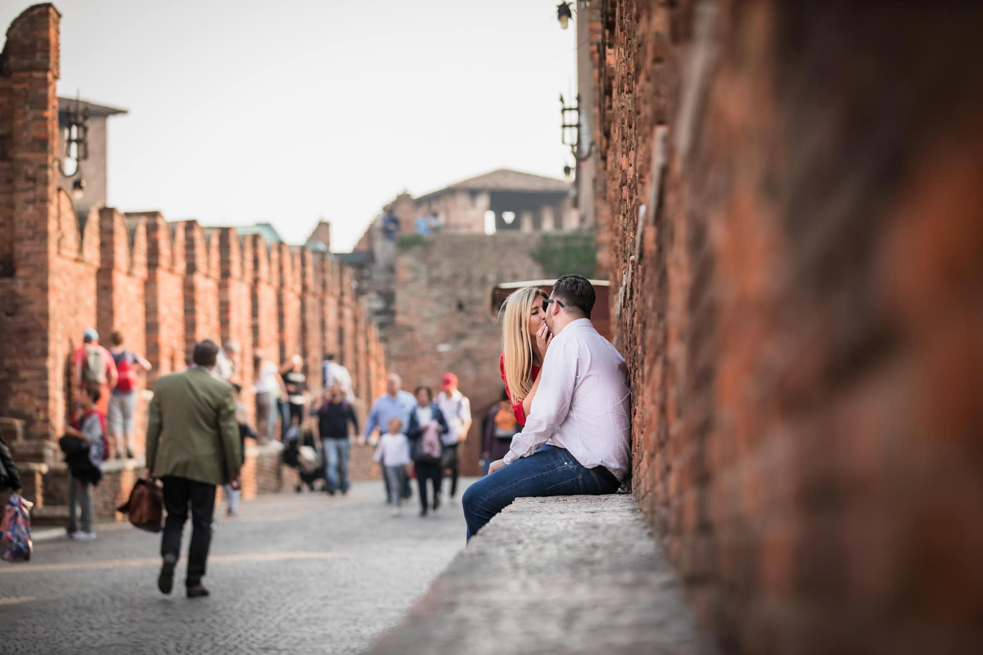 Engaged couple kissing on the Ponte Scaligero in Verona, Italy