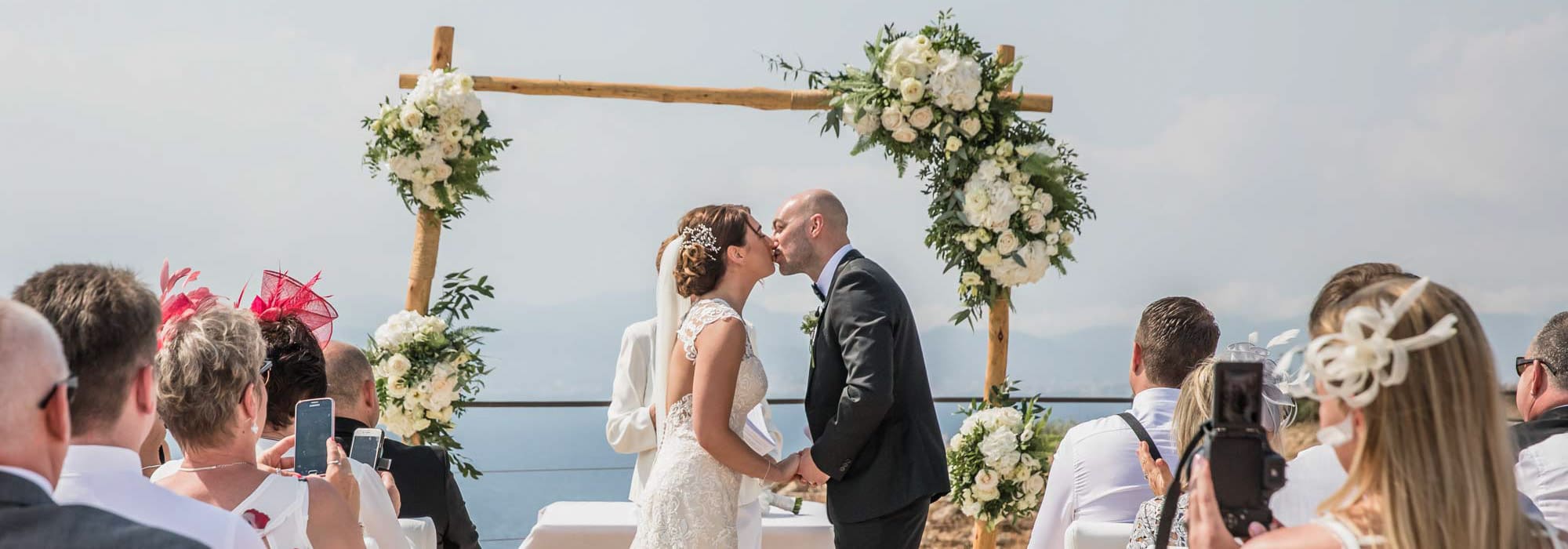 Overlooking the Mediterranean the bride and groom enjoy a first kiss after their Cap Rocat wedding