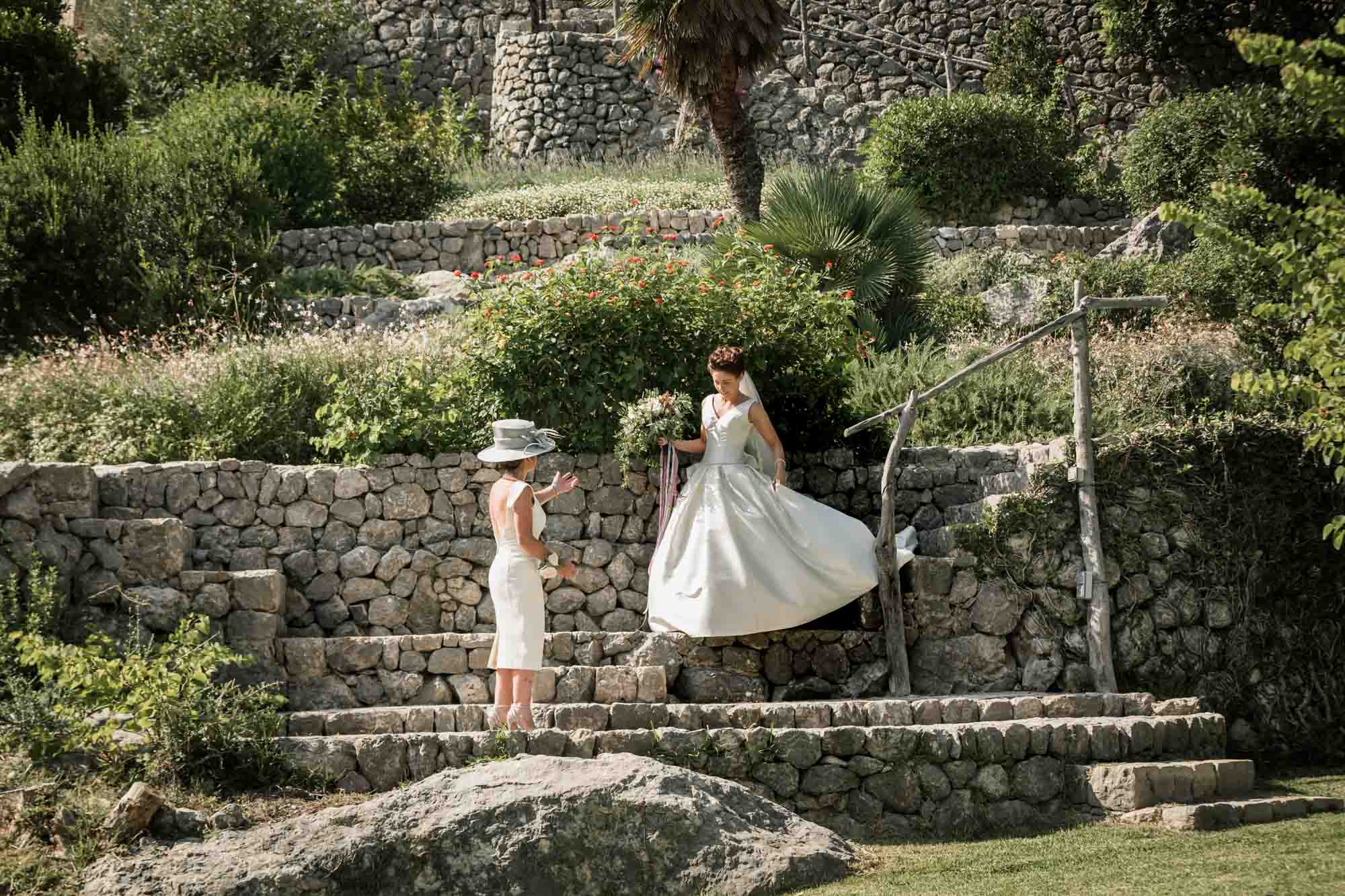 A beautiful bride descends the steps at Pedruxella Gran in Mallorca