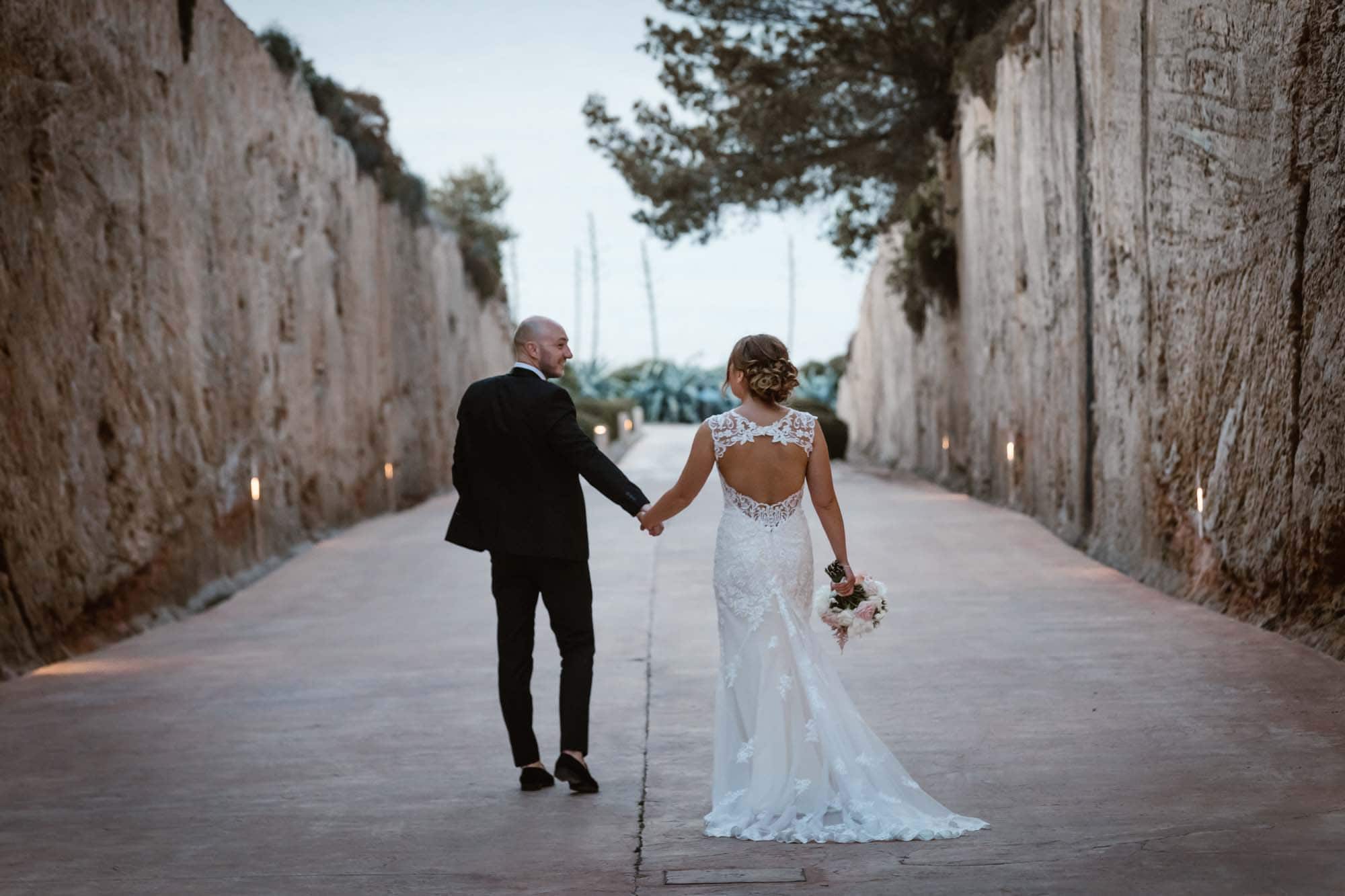 Bride and groom walk to the sea at Cap Rocat after their Mallorca wedding